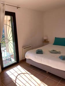 a bedroom with two beds and a large window at Villa les écureuils in Fréjus