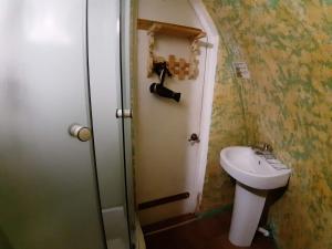 a small bathroom with a toilet and a sink at Cave Sorceress Gingemma in Petrovo