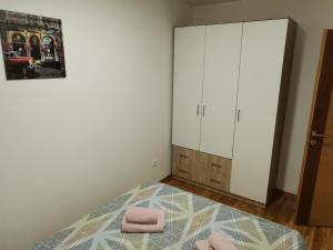 sypialnia z łóżkiem z różowymi ręcznikami w obiekcie Nina apartman w mieście Donje Mladice