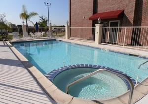 une grande piscine en face d'un bâtiment dans l'établissement Hawthorn Extended Stay by Wyndham Port Arthur, à Port Arthur