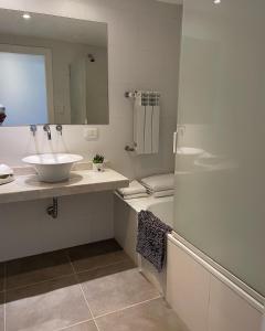 a bathroom with a sink and a mirror and a tub at Administración Maipu PB A Depto Premium in Tandil