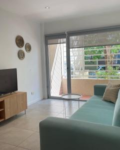 a living room with a blue couch and a television at Administración Maipu PB A Depto Premium in Tandil