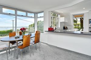 uma cozinha e sala de jantar com mesa e cadeiras em St Andrews Hill - Christchurch Holiday Homes em Christchurch