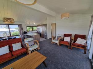 a living room with couches and chairs and a table at Relax at Pauanui - Pauanui Holiday Home in Pauanui