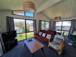 een woonkamer met een bank en een tafel bij Relax at Pauanui - Pauanui Holiday Home in Pauanui