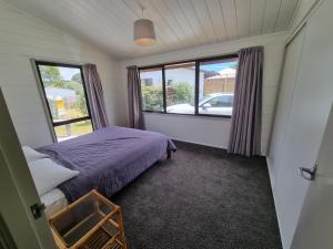 een kleine slaapkamer met een bed en een raam bij Relax at Pauanui - Pauanui Holiday Home in Pauanui