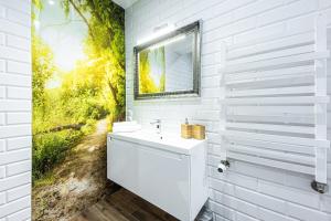 a white bathroom with a mirror and a sink at Apartament w Centrum Ostróda in Ostróda +15 photos