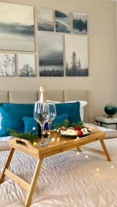 a table with a wine glass and a plate of food on a bed at MAGRI Luxurious Apartment A42 Borovets Gardens in Borovets