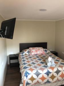 1 dormitorio con 1 cama con toallas en Hostal Luna del Mar 840-B, en La Serena