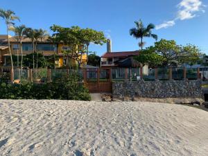 uma casa na praia ao lado de um edifício em Light Beach Residence em Florianópolis