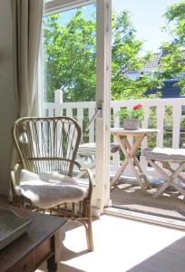 een veranda met een stoel, een tafel en een raam bij Sea shell with balcony close to the beach, city centre and dunes in Zandvoort