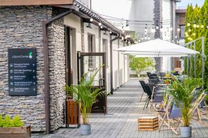 un patio al aire libre con sombrilla, mesas y sillas en JJ Sport Concept Hotel en Cracovia
