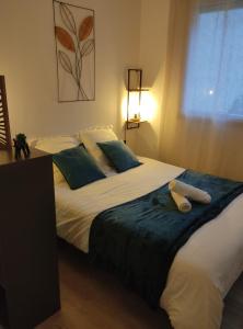Un dormitorio con una cama grande con toallas. en Villa Raphaëlle #3 Centre ville avec parking, en Le Havre