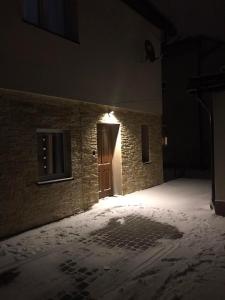 une pièce vide avec de la neige sur le sol et une porte dans l'établissement Noclegi Dukla, à Dukla