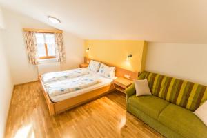 ein kleines Schlafzimmer mit einem Bett und einem Sofa in der Unterkunft Ausserraingut in Flachau