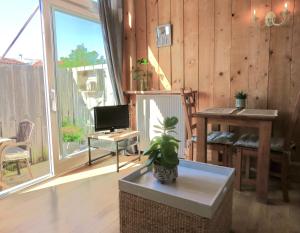 ein Wohnzimmer mit einem TV und einem Tisch mit einer Anlage in der Unterkunft Beachtime close to the beach, city centre in Zandvoort