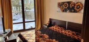 a bedroom with a bed and a large window at TERRA COMPLEX D4 - Private apartment - Golf, Skiing & SPA in Bansko +40 photos