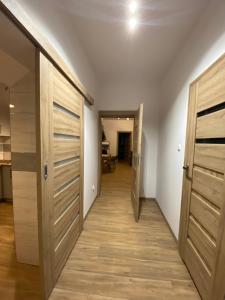 un couloir avec des portes en bois et une chambre avec une table dans l'établissement Noclegi Dukla, à Dukla