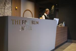 a man standing at the front desk of a hotel at The Erzurum Hotel in Erzurum
