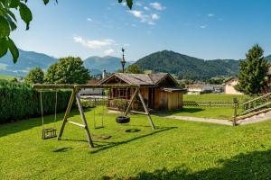 eine Schaukel in einem Hof mit einem Haus in der Unterkunft s'Wirtshaus by Alpine Genusswelten in Gröbming