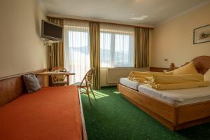 um quarto de hotel com duas camas e uma mesa em s'Wirtshaus by Alpine Genusswelten em Gröbming