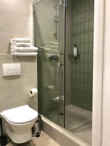 een badkamer met een douche, een toilet en handdoeken bij Modern Studio City Center дуже затишно! in Chmelnytsky