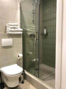 a bathroom with a shower and a toilet and towels at Modern Studio City Center дуже тепло! in Khmelnytskyi