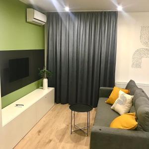 a living room with a couch and a television at Modern Studio City Center дуже тепло! in Khmelnytskyi