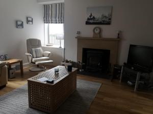 a living room with a fireplace and a television at The Fifie in Saint Monance