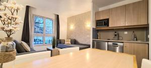 a kitchen and a living room with a table at Love N Nature in Serris