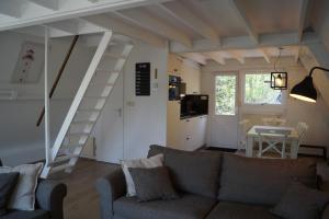 a living room with a couch and a staircase at ArdennenVakantieBungalow in Durbuy