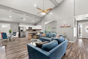 a living room with blue couches and a kitchen at CYC Mega House with BBQ Gazebo in San Antonio