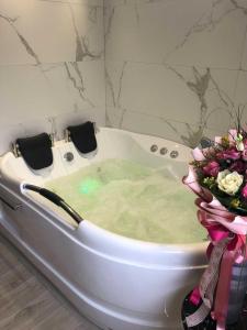 une baignoire remplie d'eau et d'un bouquet de fleurs dans l'établissement Guesthouse Dabić, à Zlatibor