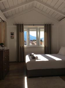 a bedroom with a bed and a large window at Apartments Bajkovic in Kotor