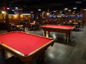 two pool tables in a bar with tables and chairs at Neighbourhood Inn Hotels in Bonnyville in Bonnyville