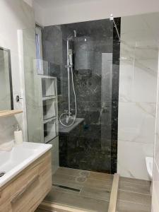 a bathroom with a shower with a glass door at Noel's Home in Korçë
