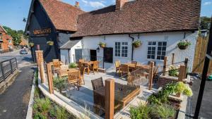 a restaurant with tables and chairs outside of a building at Modern Luxury 1 bed apartment with parking near Stansted Airport in Stansted Mountfitchet