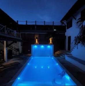 a swimming pool with blue lights in front of a building at Vila Moana Jeri in Jericoacoara