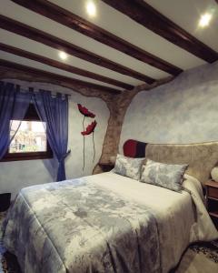a bedroom with a bed with red shoes on the wall at Casa Rural 1904 in Tubilla del Lago