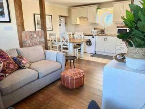 a living room with a couch and a kitchen at The Historic Wee Green House in Carrigart