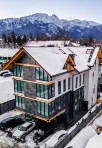 una casa con nieve en el techo en Kamieniec 27 Bed & Breakfast en Zakopane