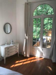 a bedroom with a bed and a dresser and a window at Appartement de charme avec parking et terrasse in Besançon