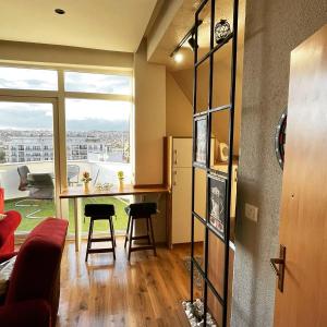 a living room with a table and a large window at ORA-PRN,cosy apartment in the city center in Pristina