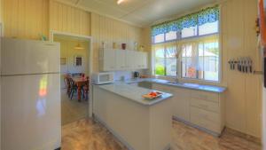 een keuken met een witte koelkast en een tafel bij The Vines Motel & Cottages in Stanthorpe