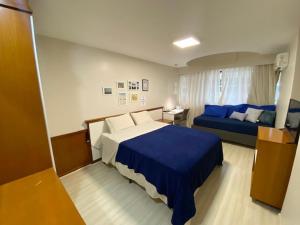 a bedroom with two beds and a desk and a bed at Aconchego com vista mar in Vila Velha