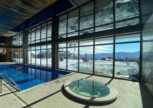 a large building with a swimming pool and a large window at Rustic House BINA 5 in Gudauri
