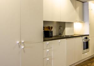 a kitchen with white cabinets and a sink at Rustic House BINA 5 in Gudauri