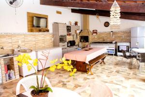 a large kitchen with a table and chairs in a room at NOVO Casa com piscina no centro de Caraguatatuba in Caraguatatuba
