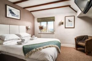 a bedroom with a large bed and a chair at The Chilterns Fox in Ibstone