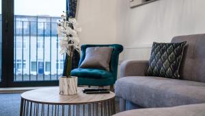 sala de estar con sofá y mesa con un jarrón de flores en LiveStay-New Private Apartment Building Minutes From Heathrow en Slough